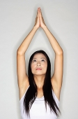 Woman practicing yoga, arms outstretched, hands together - Asia Images Group