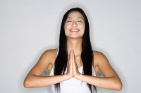 Woman practicing yoga, hands together, eyes closed, smiling - Asia Images Group
