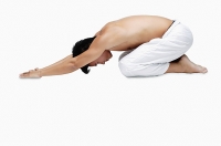 Man kneeling on floor, doing yoga - Asia Images Group
