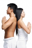 Couple standing back to back in yoga position, side view - Asia Images Group
