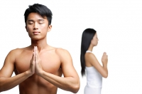 Couple doing yoga, hands together, man facing camera, woman facing away - Asia Images Group