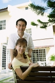Mature couple looking at camera smiling, husband standing behind wife - Asia Images Group
