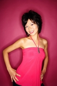 Woman in pink top against pink background, looking at camera - Asia Images Group