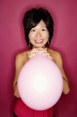 Woman holding pink balloon - Asia Images Group