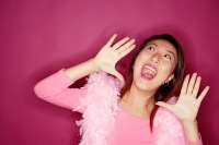 Woman wearing feather boa, shouting - Asia Images Group
