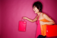 Woman carrying shopping bags, side view - Asia Images Group