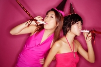 Young women with noisemakers and party hats - Asia Images Group