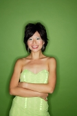 Woman in green dress, arms crossed, smiling at camera - Asia Images Group