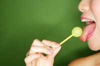 Woman licking lollipop, side view - Asia Images Group