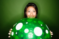 Woman holding big green inflated ball - Asia Images Group