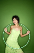 Woman in green strapless dress, with hoola hoop - Asia Images Group