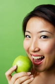 Woman preparing to bite into green apple - Asia Images Group