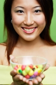 Woman holding a bowl of candy - Asia Images Group