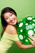 Woman hugging inflatable ball, smiling at camera - Asia Images Group