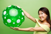 Woman with inflatable ball, arms outstretched - Asia Images Group