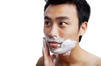 Man applying shaving cream to face - Asia Images Group