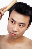 Man brushing his hair - Asia Images Group