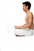 Man sitting in lotus position, side view - Asia Images Group