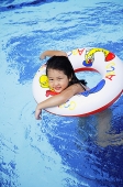 Girl in swimming pool using inflatable ring - Asia Images Group