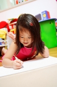 Young girl lying on floor drawing - Asia Images Group