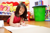 Young girl on floor, drawing on paper - Asia Images Group