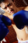 Man with boxing gloves, looking at camera - Asia Images Group