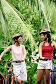 Two women with bicycles, smiling - Asia Images Group