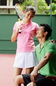 Couple in tennis outfit, smiling at each other - Asia Images Group