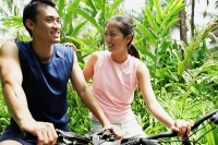Couple on bikes, woman with hand on mans shoulder - Asia Images Group