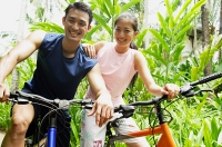 Couple on bicycles, smiling - Asia Images Group