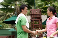 Man and Woman shaking hands on tennis court - Asia Images Group