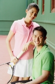 Couple in tennis outfits, looking at camera, smiling - Asia Images Group