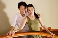 Couple on staircase, smiling at camera, portrait - Asia Images Group