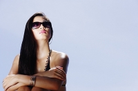 Woman with sunglasses, arms crossed, looking away - Asia Images Group
