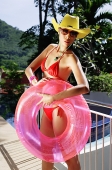 Woman in red bikini, sunglasses and hat, holding inflatable ring - Asia Images Group
