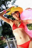 Woman in red bikini, sunglasses and hat, smiling - Asia Images Group