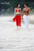 Couple walking, holding hands, along beach - Asia Images Group