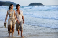 Couple walking on beach, looking away - Asia Images Group