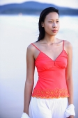Woman in red top, standing, looking away - Asia Images Group