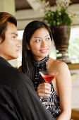Well dressed couple, looking away, woman holding a drink - Asia Images Group