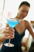 Woman sitting at bar counter, holding cocktail, selective focus - Asia Images Group