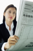 Businesswoman reading newspaper, selective focus - Asia Images Group
