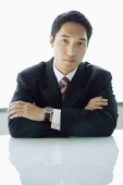 Businessman sitting, arms crossed - Asia Images Group