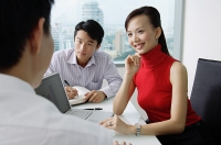 Executives having a discussion, woman smiling - Asia Images Group