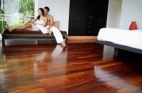 Couple at home in bedroom, sitting on daybed - Asia Images Group