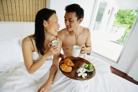 Couple having breakfast in bed - Asia Images Group