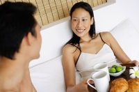 Couple in bed having breakfast - Asia Images Group