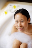Woman in bathtub, smiling at camera - Asia Images Group