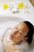 Woman in bathtub, eyes closed, head shot - Asia Images Group