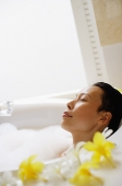 Woman in bathtub, eyes closed - Asia Images Group